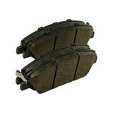 Friction-face view of both pads showing light-brown/tan friction compound with moulded transverse slot and chamfered leading/trailing edges, surface clean with no glazing or rotor wear