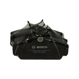 Top-down view of the four black-painted brake pads wrapped together in clear shrink film, with a coiled wear-indicator wire and a spring clip visible above the pads; lead pad stamped BOSCH, '0 986 AB9 296-HX6', batch code '62009 25X BNA116', and 'MADE IN TAIWAN'