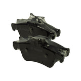 Angled view of both pads stacked, wear-indicator spring clip on the upper pad clearly visible