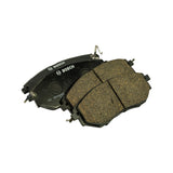 Angled view of one pad flipped to show backing plate with Bosch branding and another sitting friction-side up, highlighting the two-piece slotted friction face and mounting hardware