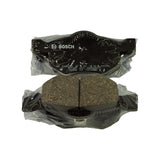 Single pad shown from both sides still in its bag: backing plate view with Bosch logo and full stamping visible, and friction-material view showing the central anti-squeal slot in the friction pad