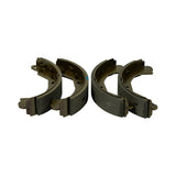 All four shoes laid out in two facing pairs on a white background showing leading and trailing shoe profiles with mounting tabs at each end