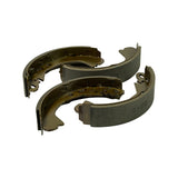 Four shoes arranged with friction surfaces and metal backings both visible, showing the riveted lining attachment, return spring holes and self-adjuster slots