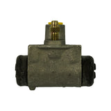 Top-down view of the cast aluminium cylinder body, brake line fitting and bleeder nipple with yellow plastic cap visible on the raised boss, dust boots on both piston ends