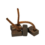 Four carbon brushes grouped together, viewed from above-front. Braided copper leads visible in varying lengths — two longer woven leads and two shorter stiffer leads. Carbon body surfaces appear clean and unworn, consistent with new old stock.