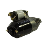 Starter motor, rear-left three-quarter view showing commutator end and motor body. Two brush-holder screws and commutator port visible on black end cap. Full unit condition apparent — no visible corrosion or damage.