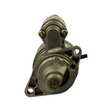 Drive-end (front) view of starter motor showing two-hole bolt flange mounting pattern, nose cone with exposed 9-tooth helical pinion gear at rest, and small vent port on the field housing.