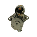 Drive-end face and solenoid top-down view. Two-hole mounting flange visible with unthreaded ears. Commutator end cap removed revealing brush plate and through-bolt heads. Cast housing shows smooth machined bore. Casting marks partially visible on armature endplate, including 1K121.
