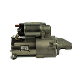 Left-side profile of starter motor showing opposite side from solenoid. Black QC sticker reads PASSED in bold, Korean characters (권익상), and Remy Korea branding. Yellow dot sticker visible on solenoid top. Drive gear partially visible at nose.