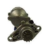 Front/drive-end view showing the nose cone mounting flange with two large bolt holes, the exposed pinion gear teeth, and partial solenoid body at upper-left. Connector tabs visible — yellow and blue.