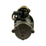 Rear/commutator-end face of starter motor viewed straight on. NIKKO sunburst logo cast into the centre of the rear end cap. Four through-bolts visible at corners. Solenoid terminal block assembly visible at top with main terminal stud, small terminal stud, and rubber boot cover. Braided earth strap visible.