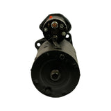 Rear/commutator-end view showing circular end cap with two exposed brush access screws and central shaft stub; solenoid head visible at top with copper terminal post
