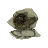 Impeller-side view of the bagged pump, showing six-vane pressed-steel impeller, central shaft hub, cast aluminium housing with four peripheral bolt holes, and the paper gasket visible beneath in its own sealed bag