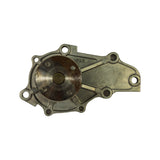 Rear (engine-side) face of pump; circular shaft bearing plate showing light surface oxidation/discolouration; 'JAPAN' text cast into the pump body visible at upper right; seven bolt holes around perimeter.