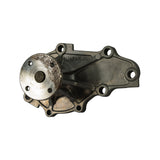Alternate rear-angle view of pump body; 'JAPAN' cast marking clearly visible mid-body; machined shaft bearing flange showing age-related surface staining; casting quality and structural condition appear undamaged.