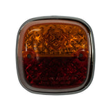 Front face of lamp, straight-on view. Upper half amber faceted lens with moulded Hella logo in centre; lower half red faceted lens. Two mounting hole bosses visible at left and right edges. Moulded text on red section reads 'MADE IN AUSTRALIA REG DES 3208'.