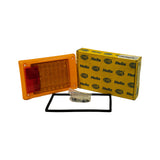 Full kit laid out: amber/orange rectangular LED module with integrated red reflex reflector panel at left side, rectangular rubber gasket/seal frame, small hardware bag with mounting screws, and Hella branded yellow box in background. Shows all included components.