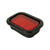 Three-quarter front-angle view of lamp in grommet; red lens and full black grommet profile visible; depth of lamp body evident; 'TRUCK-LITE' and 'JAMESTOWN N.Y.' visible on grommet edges