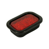 Three-quarter front-angle view from opposite side; confirms rectangular form factor, red lens, and full grommet profile; unit appears unused and in excellent condition
