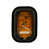 Rear/back face of lamp showing amber-tinted PCB housing with visible circuit board and LM317T IC chip; white sticker reads '10-30V / REAR TURN'; wire colour coding labels (WHT, RED, BLK) printed on PCB; green and white leads visible; grommet back open-frame design.