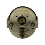 Rear view of gauge showing circular aluminum housing, central black electrical connector block with brass terminals, two M4 stud terminals flanking bracket, and partial label visible at top.