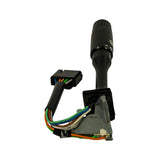 Three-quarter rear view showing stalk body pointing upward with connector hanging to lower left; multi-pin connector face visible; wiper symbol and position markings on stalk shaft; wire colours (orange, green, blue, white, brown) clearly visible.