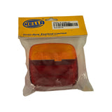 Rear of retail card showing 'Hella-New Zealand Limited, P.O. Box 51427, Pakuranga, Auckland 6.' Retailer stock label overlay reads 'Hella 9.2396.01' with barcode and 'ELE-00779' stock code. Lens clearly shows two-section moulded form — rounded amber upper half and rectangular red lower half — through clear poly bag.