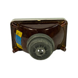 Rear view of headlight insert — dark brown painted reflector housing with four corner mounting clips, central circular bulb access port with grey plastic dust cap fitted; Hella label with 'Linksverkehr' / 1LB 003177-30 / H4 markings visible on left side.