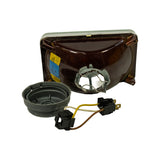Rear of unit with dust cap and sealing boot removed; H4 bulb retaining wire clip exposed inside the bulb aperture. Sealing boot (grey rubber) and three-wire harness with two connectors laid beside the unit, showing contents of the box.