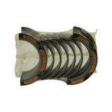 Top-down view of the full set of curved bearing half-shells vacuum-sealed in clear plastic, bright steel backs with exposed copper-alloy lining at the parting edges
