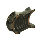 Angled three-quarter view of the sealed pack showing the stepped flange on the thrust bearing and the oil-feed holes drilled in the plain shells
