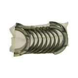 Top-down view of the bearing stack in clear plastic wrap; ten half-shell bearings nested together with one wider flanged thrust half-shell visible at the rear of the stack