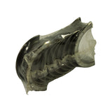 Angled end-on view of the stack through the plastic wrap, showing the concave bearing surfaces and the locating tangs on the shell ends