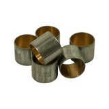 Six bushings grouped together showing bronze inner bearing surface and steel outer shell, one bushing raised showing P1-2300 STD NDC stamp on outer face