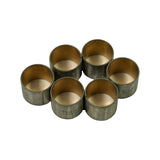 Six bushings arranged in a flower pattern bore-up, showing bronze inner surface and consistent size across all units, one unit displays P1-2300 STD NDC stamp