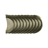 Close-up of bearing half-shells stacked face-on, showing smooth bimetal bearing surface (silver-tone aluminium alloy overlay) with steel backing visible at edges. Plastic protective film wrapping partially visible at top. No scratches or contamination on bearing faces.