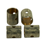 Top-down detail of four bushes: two standing showing oil hole through the wall and the wrap-type butt-joint seam, two lying flat showing the laser-etched 'P1-2401 -STD NDC' marking across the steel backing. Bronze lining visible inside.