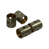 Three bushes arranged to show the bronze inner bore, the split seam on the outer steel shell, and the oil hole drilled through both layers. Machined inner surface visible.