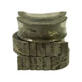 Close-up edge-on view of the bearing stack showing flanged thrust shells on top and the embossed part markings M7703AM and 030 on the edges of the plain main shells