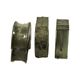 Three individual shrink-wrapped sub-bundles stood on end — a flanged thrust main on the left showing MB7703AM stamping, and two stacks of plain main shells to the right