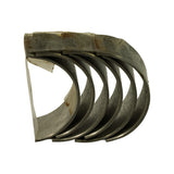 Stacked bearing shells viewed from the oil-groove side, showing the machined running surface and the taped-together bundle at one end