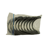 Top-down view of bag revealing the full bearing set nested in pairs, one wider shell with thrust flange visible at the left end consistent with a split-thrust main bearing arrangement