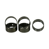 Three cam bearings standing on end, two larger and one smaller, displaying the circular cross-section and seam where the rolled shell meets.