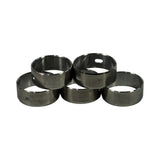 Five cam bearings arranged in a pyramid, showing variation in width and oil hole placement between the shells including a slotted oval aperture on one bearing.