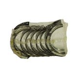 Top-down view of sealed bundle showing yellow waxy VCI corrosion-inhibitor paper strip laid through the shell stack