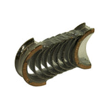 Three-quarter angle of wrapped bearing set showing the cast copper-lead second layer exposed at the parting edges