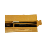 Opposite-end view into open box showing two-compartment tray from the right side; compression rings visible left, curved oil control ring rails visible right with instruction slip tucked in divider.