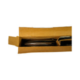 Close-up top-down view into open box, emphasising the wavy gold expander rings on the left and the cardboard divider separating them from the flat dark rings on the right. Multiple ring layers are visible, consistent with a 4-cylinder set.