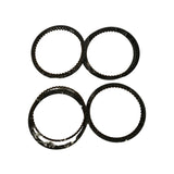 Same four ring packs from a slightly different angle, confirming all four are present and undamaged. Oil control ring expanders and rails are visible protruding slightly from each pack.