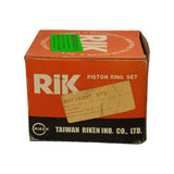 Front face of orange RIK cardboard box showing brand name, 'PISTON RING SET' text, and handwritten label reading 'RST-12HT STD / RING SET TOYOTA 12HT 2-5mm 1/2 KEY TOP 2.5mm / 91mm BORE / PRT060S101D / Segedin Truck & Auto Parts Ltd'. Green IMPORTANT sticker visible on top. Box shows age-related scuffing and creasing.
